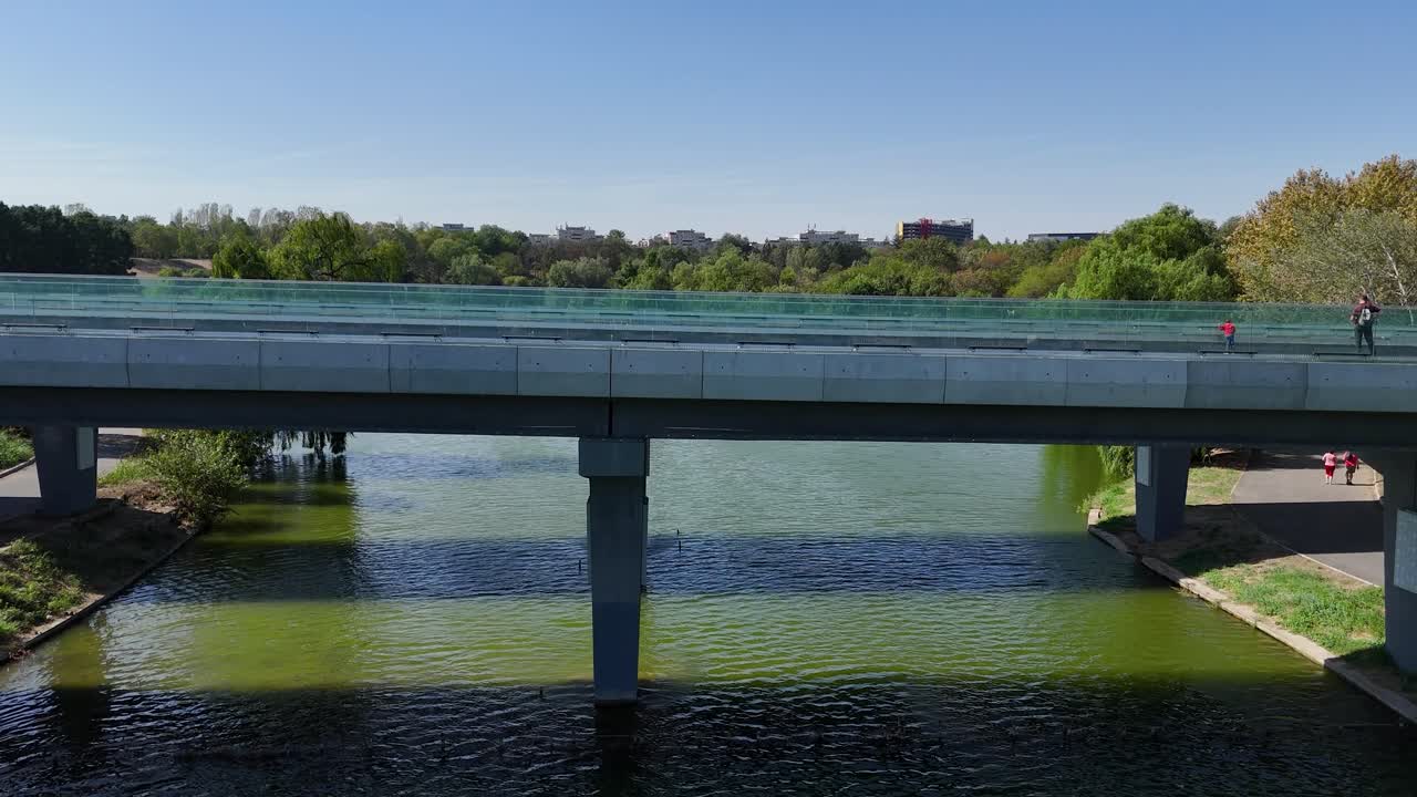 Aerial View of a Bridge Over a Lake in a City Park