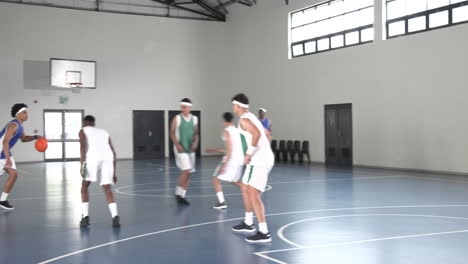 basketball players competing intensely on indoor court, focused on dribbling skills