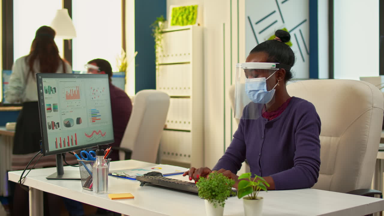 Black woman working on computer in new normal office