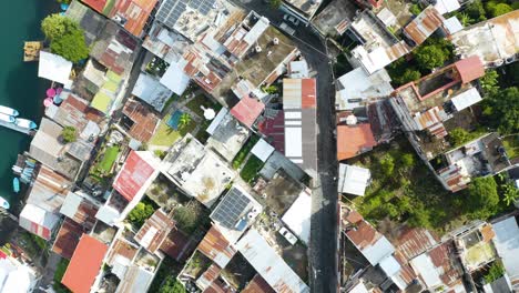 Drone-De-Arriba-Hacia-Abajo-Desciende-Sobre-La-Carretera-Y-Las-Casas-Destartaladas-Del-Lago-De-Atitlán,-Guatemala