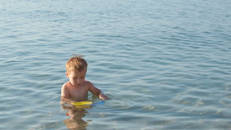 little boy playing in the shallow sea