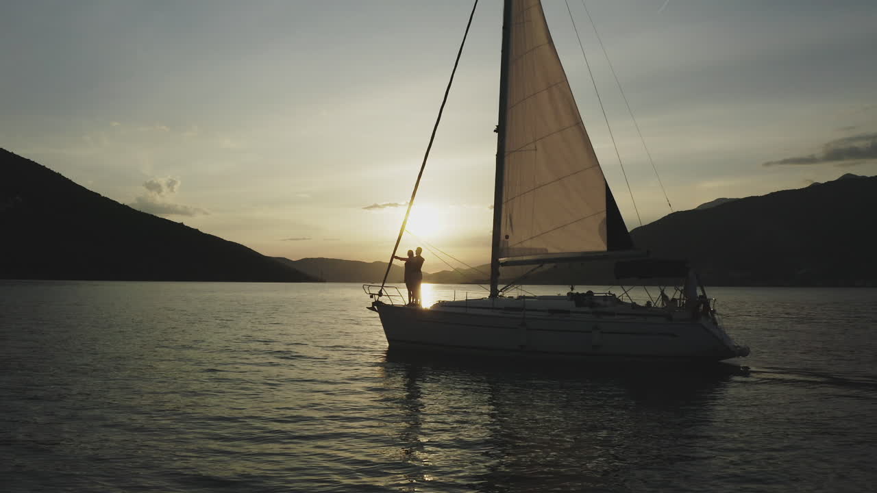 Una pareja en un yate al atardecer.