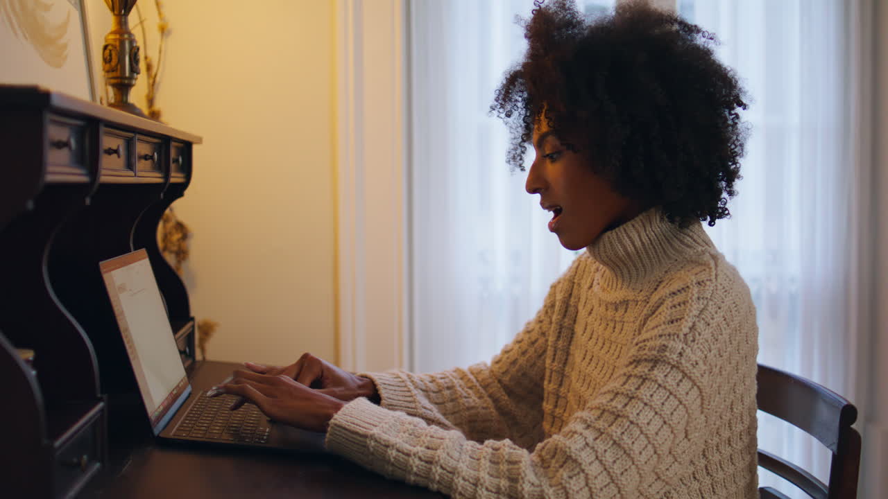 Inspired model texting laptop at wooden desk workplace. Curly hair lady chatting