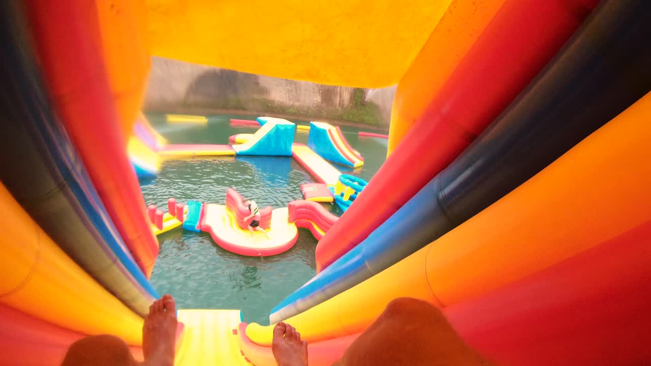 Girl Jumping into Water at Inflatable Water Park