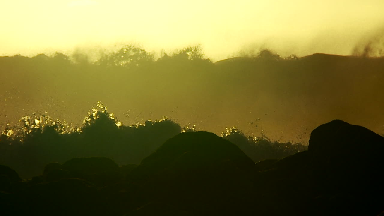 grandes olas a medida que alcanzan la cresta y se rompen en cámara lenta al atardecer 4