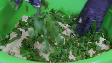 añadiendo menta fresca al relleno mientras se hace la flaouna
