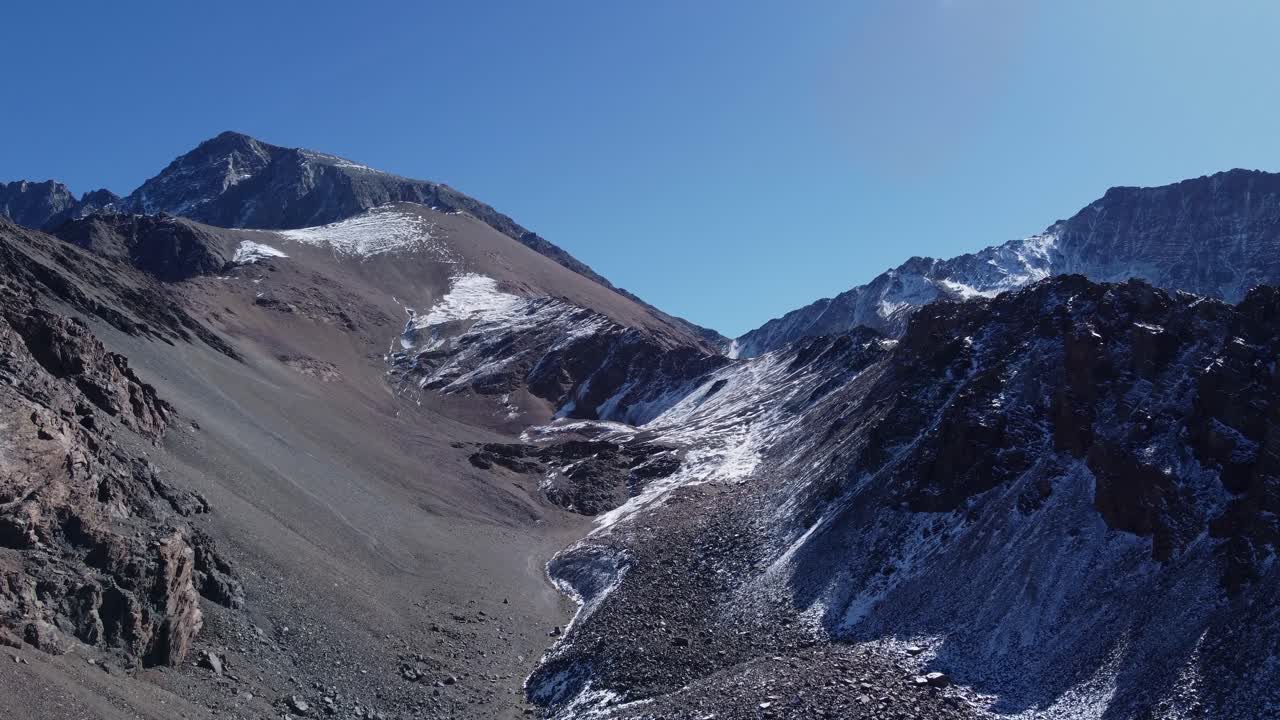 se eleva en el aire sobre las desoladas montañas alpinas nevadas, el cielo azul copia el espacio