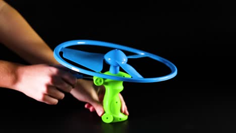 hand operating a pull string flying toy