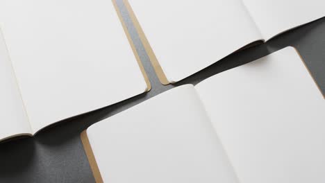 close up of open blank books with copy space on gray background in slow motion