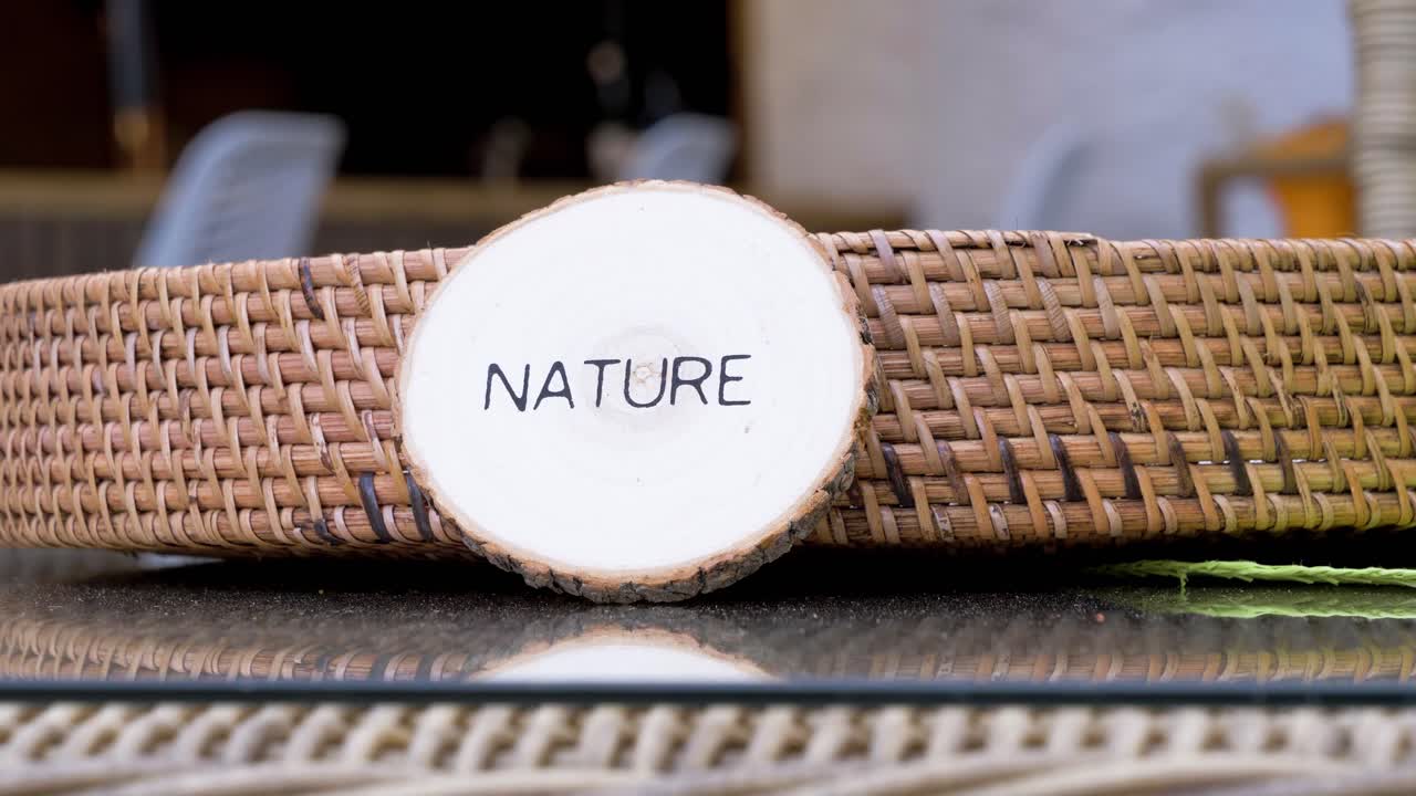 Slow orbiting shot of a wicker table with nature signage
