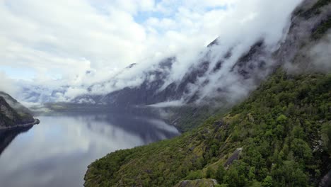 aerial view of smooth reflective lake eidfjordvatnet with clouds rolling down valley