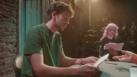 actors rehearsing on stage with female theater director