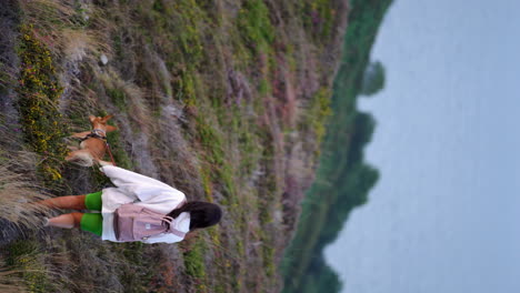 Happy-mixed-race-woman-girl-walking-trekking-in-remote-destination-with-her-dog