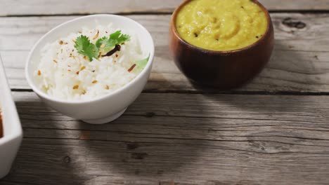 video of bowls with diverse dips lying in row on wooden surface