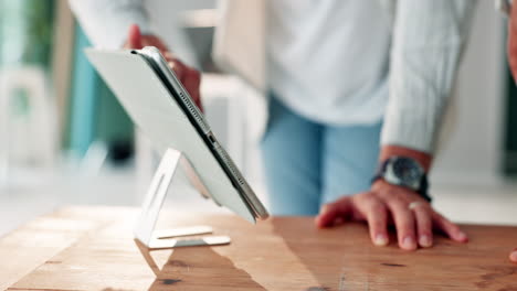 man using tablet on wooden desk