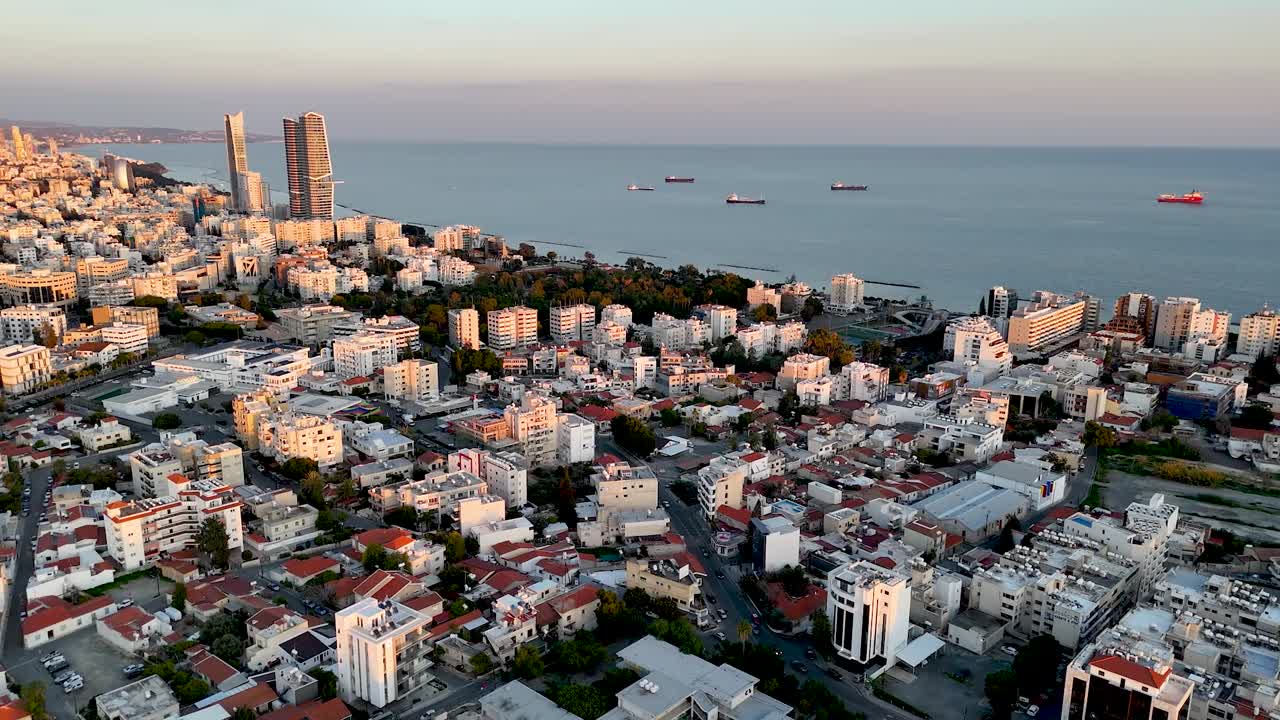 Descubre el impresionante horizonte de una animada ciudad costera durante el atardecer. La luz cálida se refleja en los edificios y el mar, creando una atmósfera pintoresca.