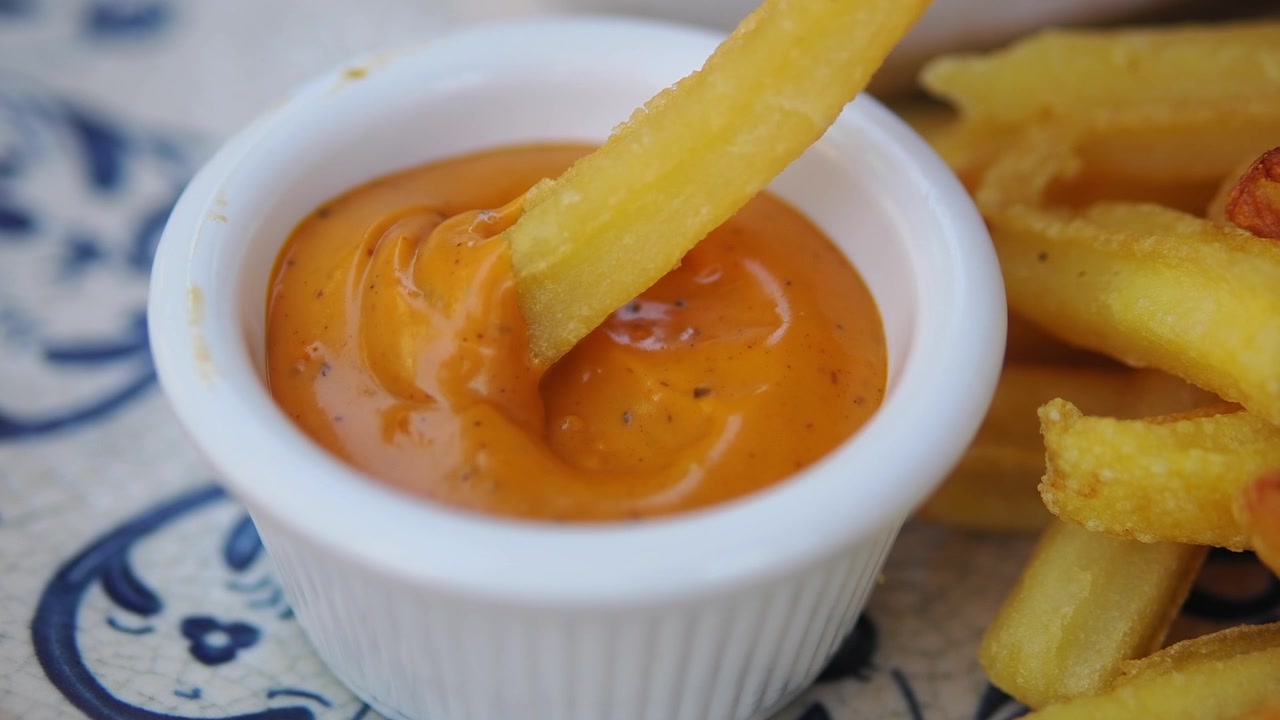 French Fry Dipped in Creamy Orange Sauce