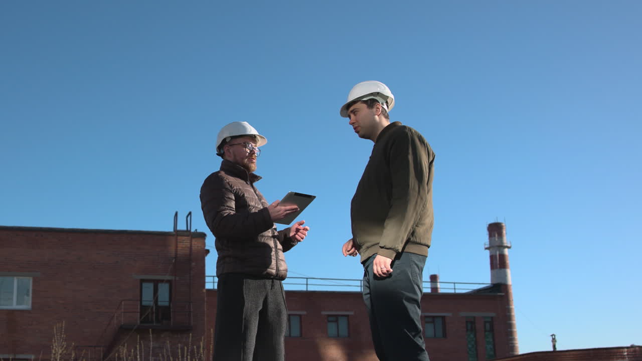 Two Professionals Exchange Documents On Rooftop During Formal Handover And Site Approval Meeting