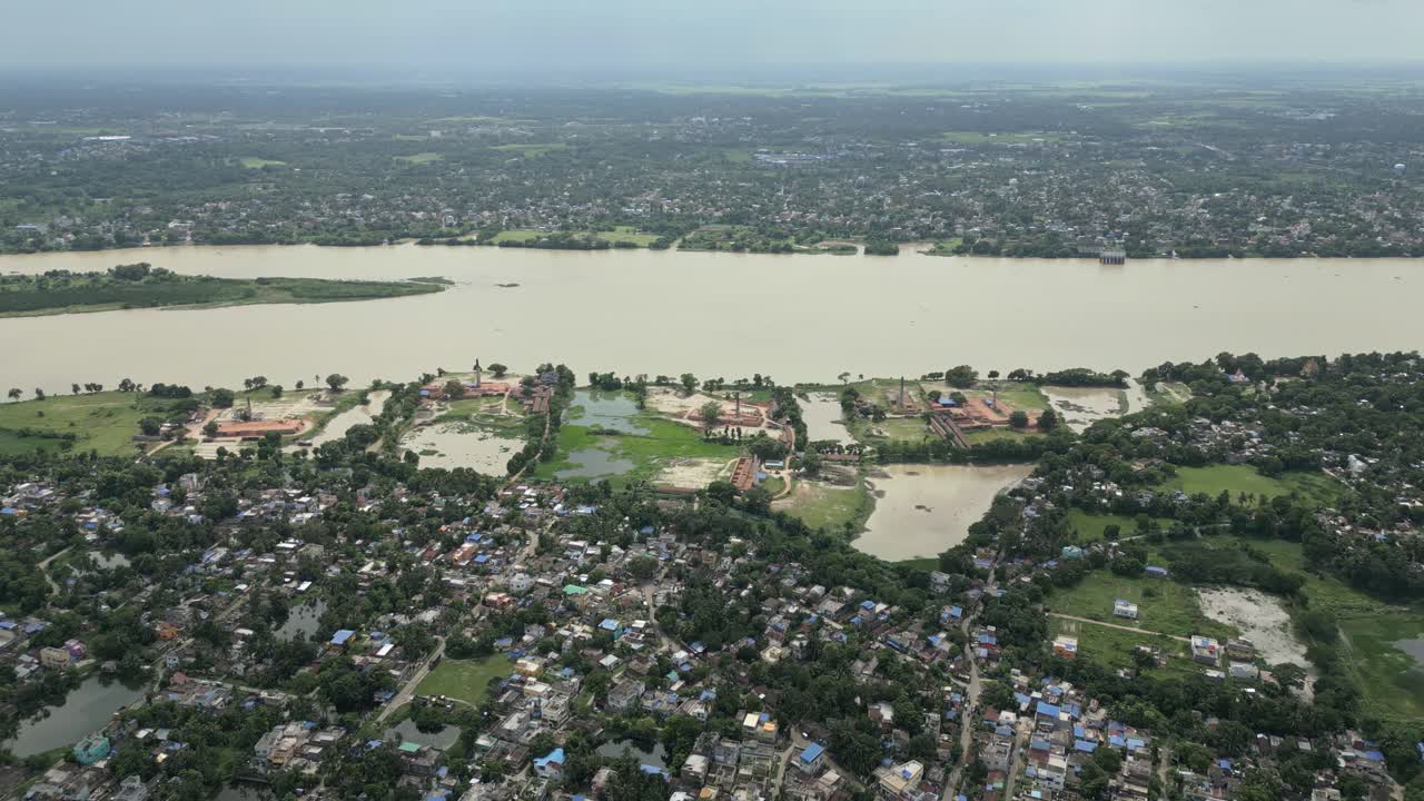 Un'ampia ripresa aerea che cattura il fiume Hooghly che scorre attraverso Kolkata, Bengala Occidentale, mostrando la densità urbana e la fornace di mattoni vicino al fiume