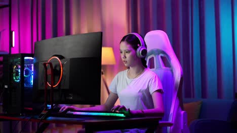 una adolescente asiática seria jugando videojuegos en la computadora