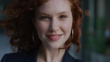 close up portrait young beautiful business woman turns head smiling happy wind blowing hair cute red head female feminine beauty slow motion