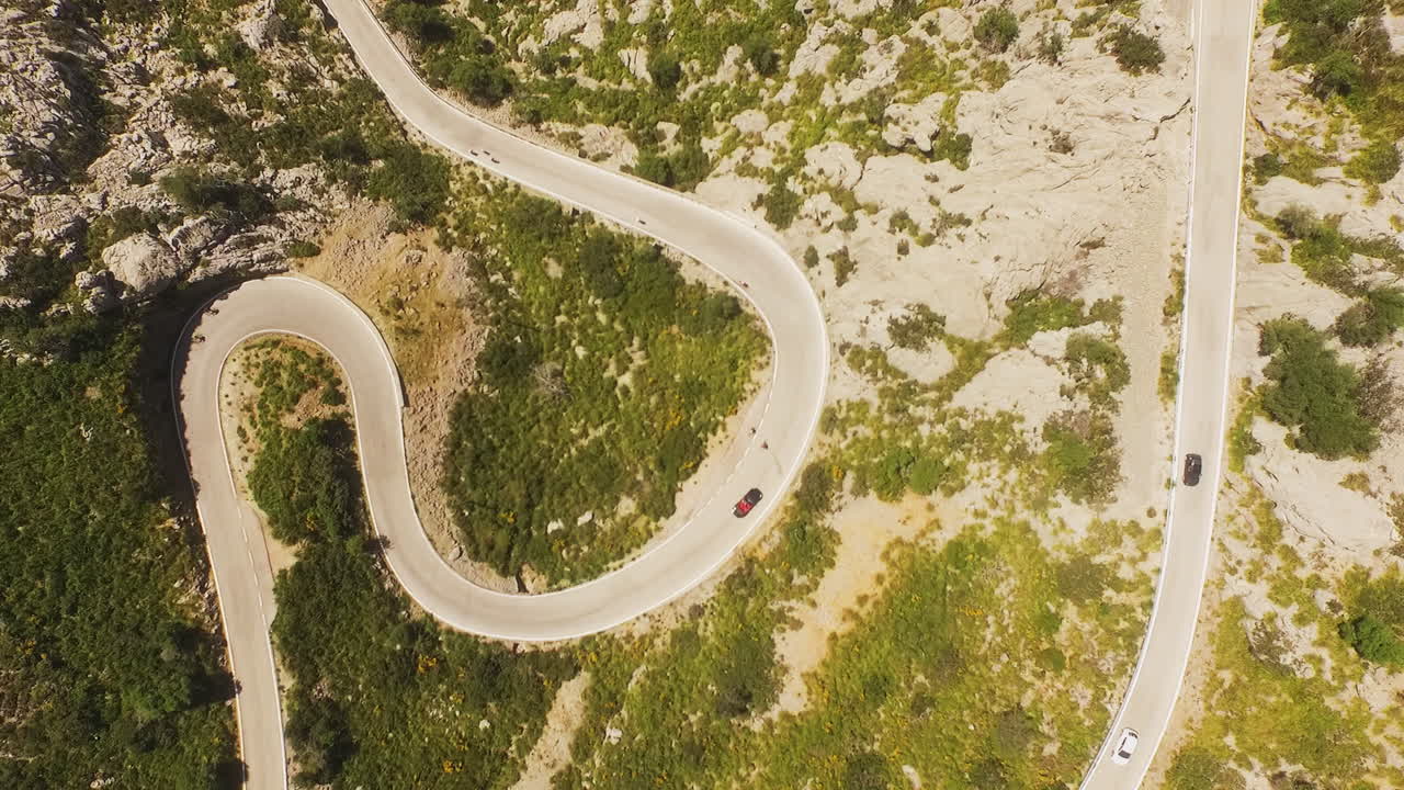 Top-down aerial view following a car on winding mountain roads on the island of Mallorca