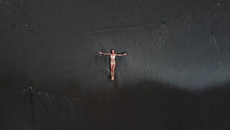 Woman Relaxing on a Black Sand Beach