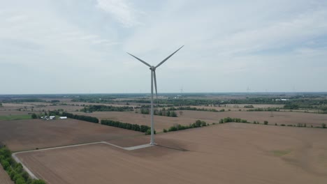 Vista-Aérea-De-Un-Dron-Que-Se-Acerca-A-Las-Aspas-Giratorias-De-Una-Enorme-Torre-De-Generación-De-Energía-Eólica