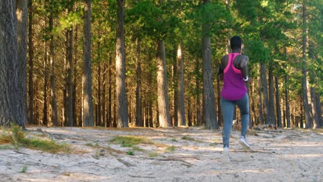 female athlete jogging in the forest 4k