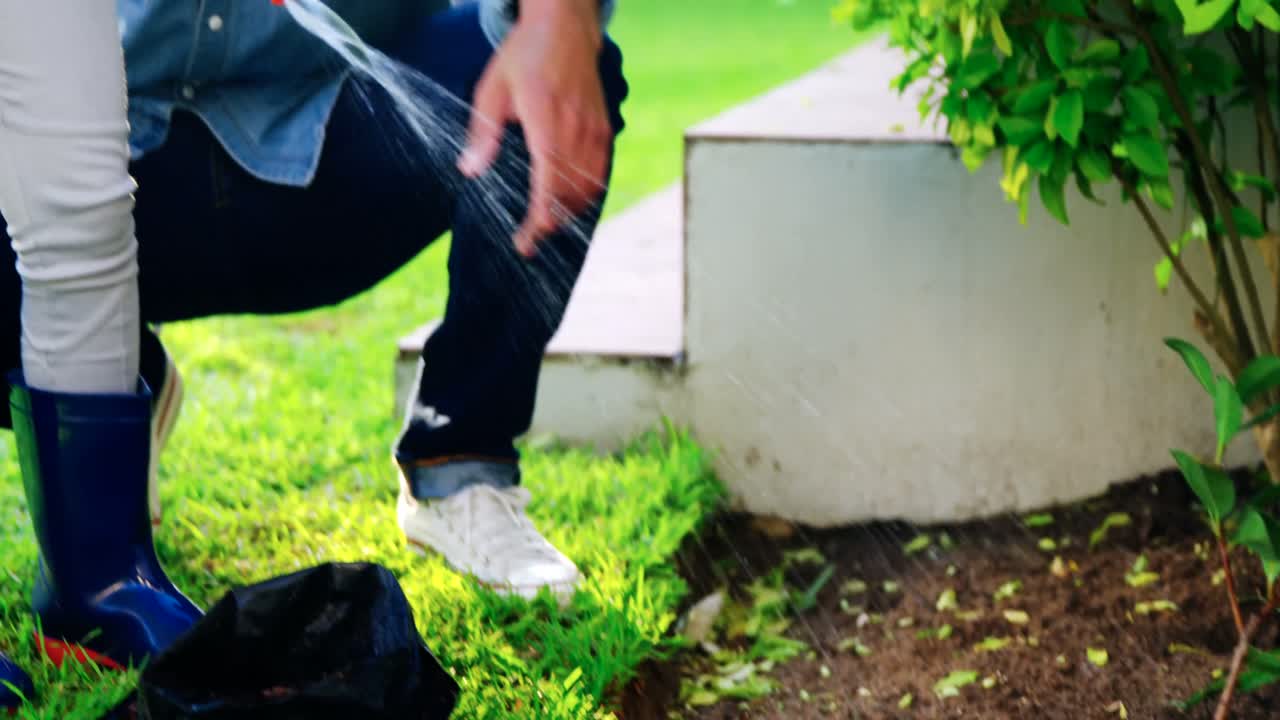 padre e hija rociando agua para plantar