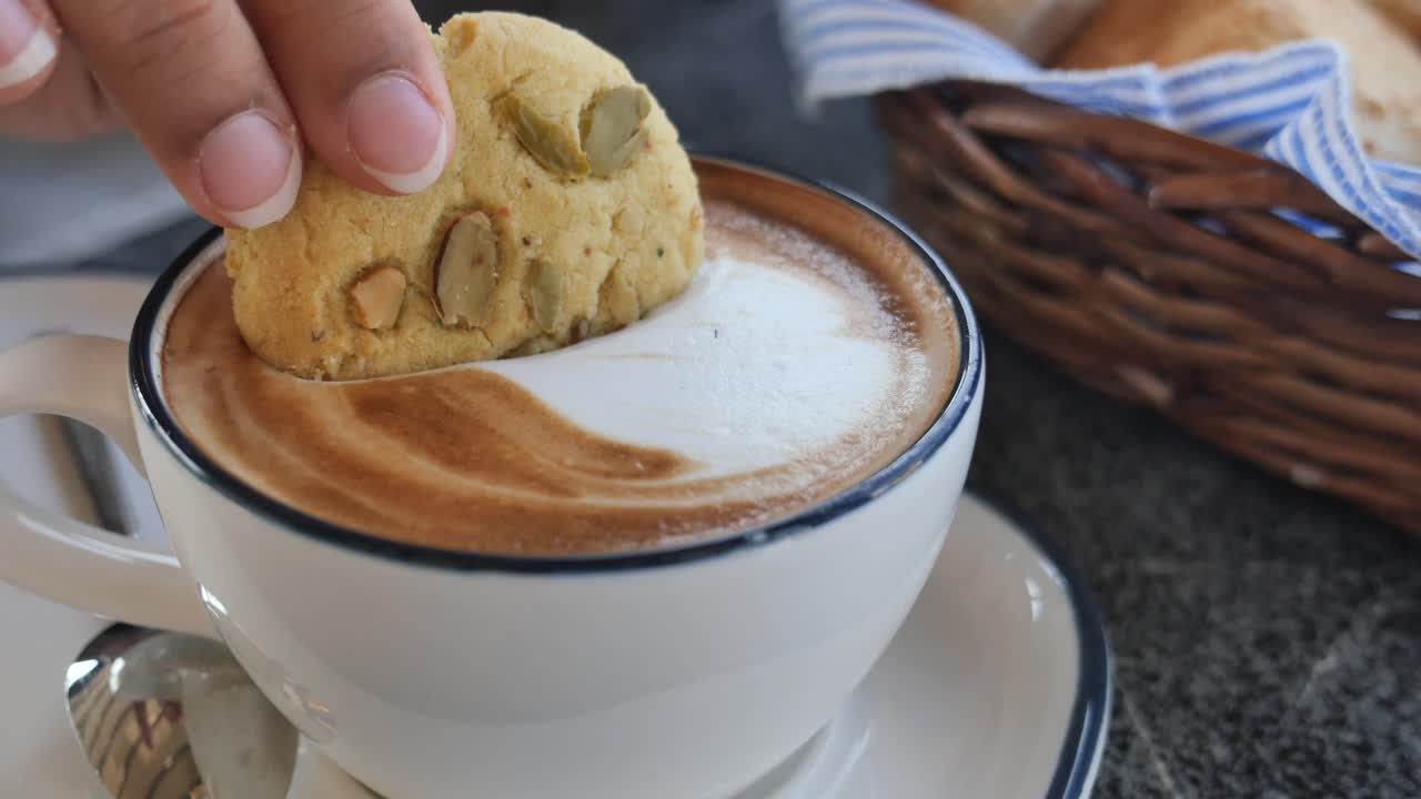 Cookie being dipped in coffee