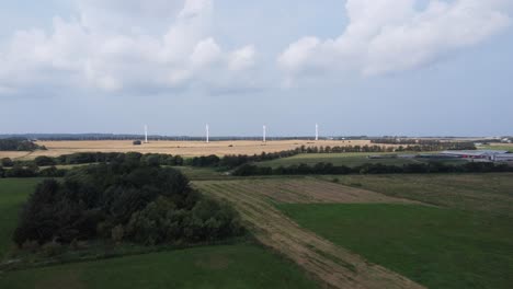4-Windturbinen-Auf-Einer-Wiese-Mit-Schönen-Wolken-Am-Himmel-Im-Hintergrund,-In-Dänemark