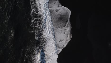 volcanic basalt beach with waves of atlantic ocean in island