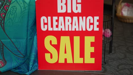 big clearance sale bright red white and yellow sign in small local business department store shop in mall during retail apocalypse