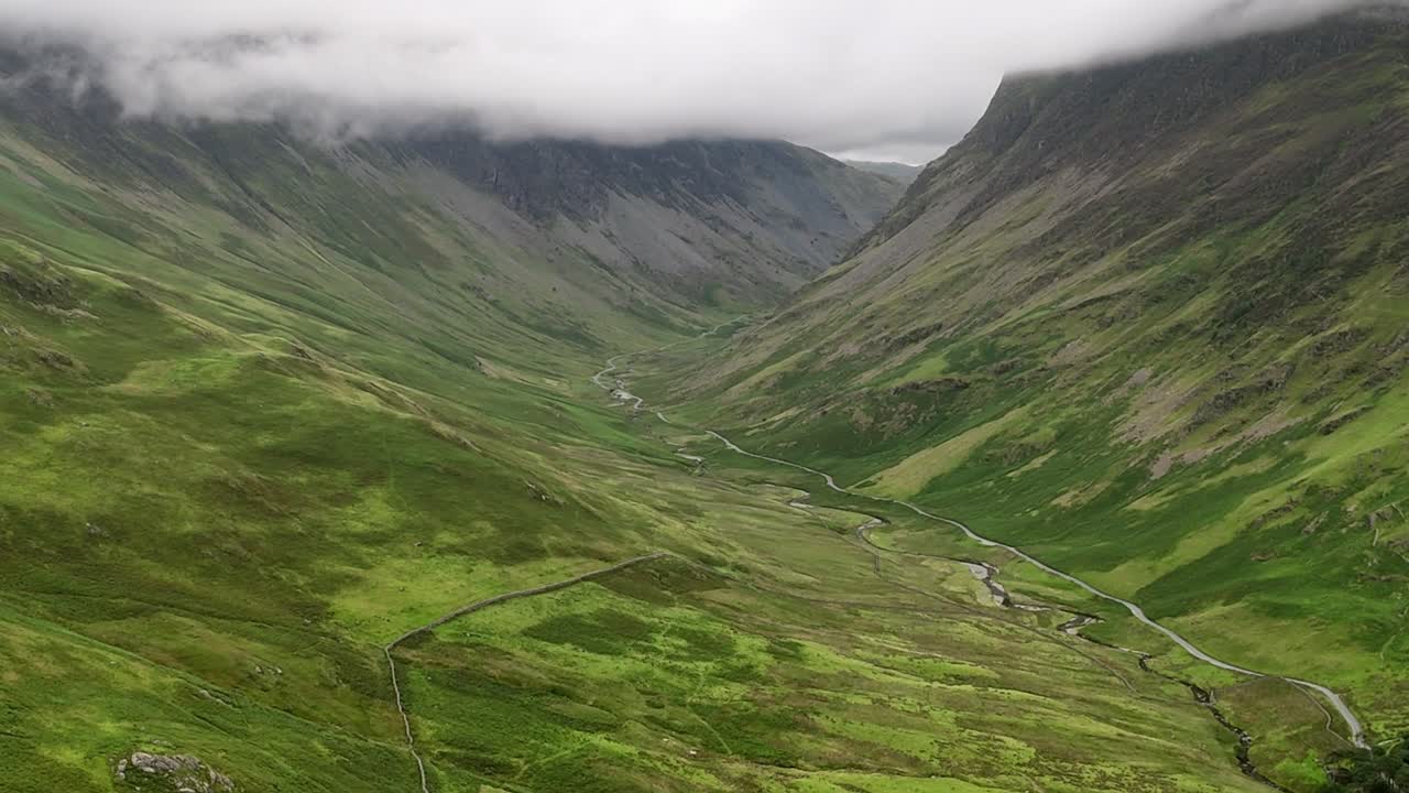 Riprese aeree dell'Honister Pass nel Parco Nazionale del Lake District in Cumbria nel Regno Unito, una strada e una valle panoramica. Nuvole e nebbia di montagna