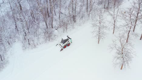 clearing snow on a rural property with a wheeled bobcat