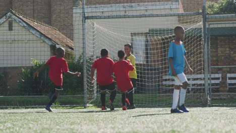 soccer kids in red smiling and cheering up in a sunny day