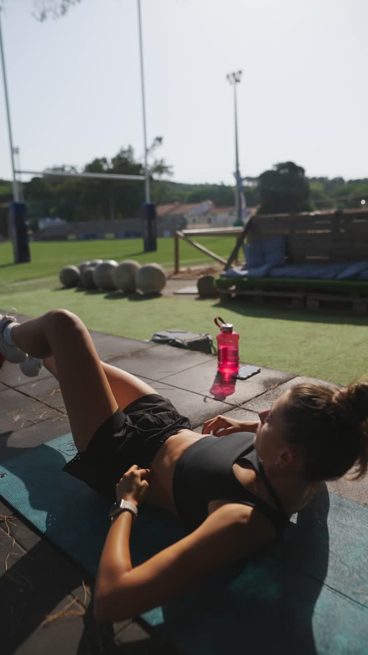 mujer haciendo ejercicios abdominales al aire libre