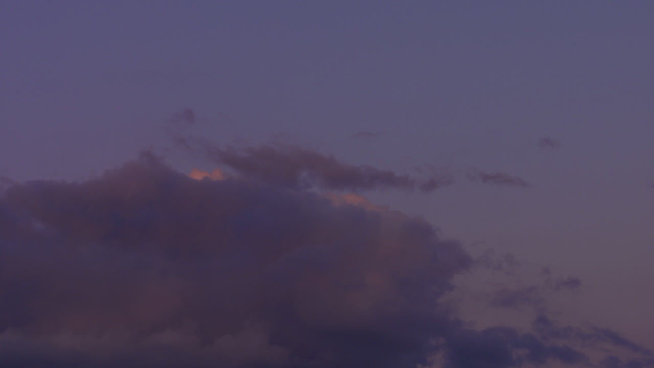 해질녘 하늘을 가로지르는 분홍 구름의 장대한 시간 경과