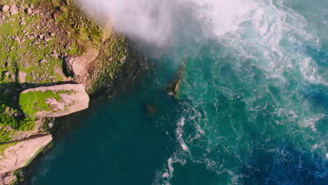 panning upward shot of niagra falls with water spraying in the air