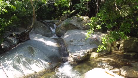 low-aerial-moving-toward-rushing-tropical-mountain-stream-in-Minca,-Colombia