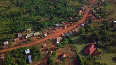 motorcycles driving on a dusty street in luweero, uganda - drone shot
