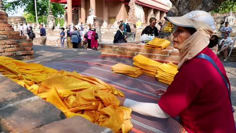 monk organizing yellow robes at temple site