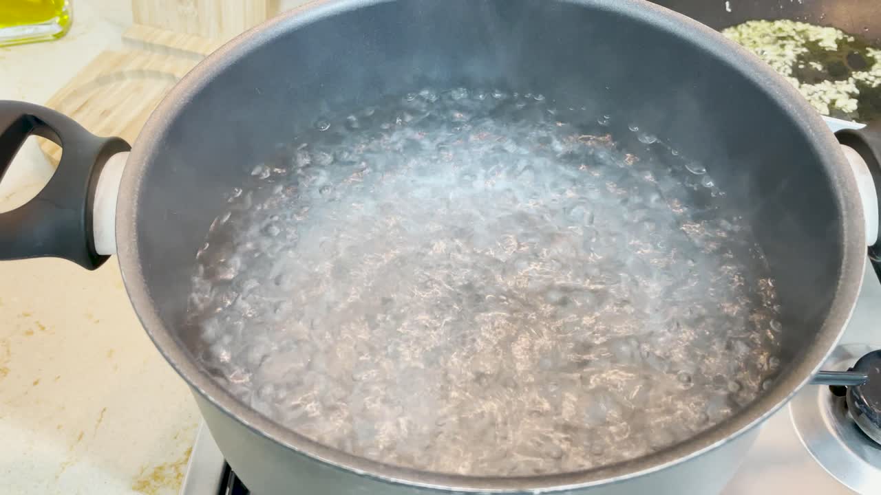 Boiling water on a pot and braised onion for a home made meal