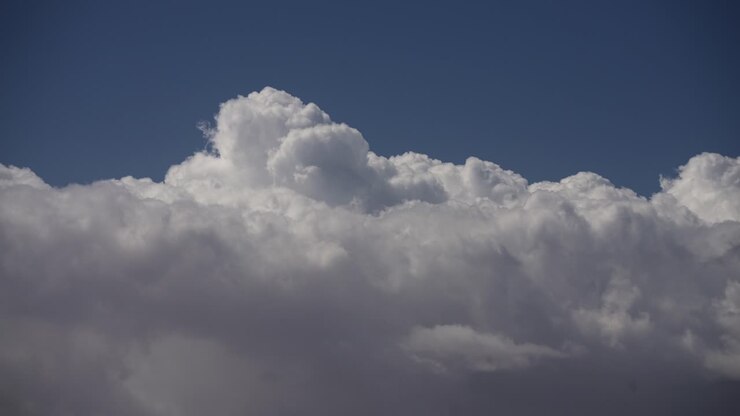 Dynamic cloudscape with huge cumulus clouds boiling and rolling across the sky - time lapse