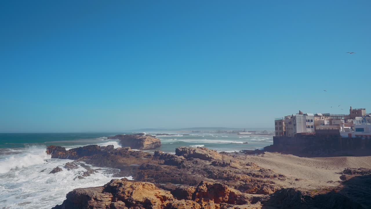 Escena de pueblo costero con olas y rocas
