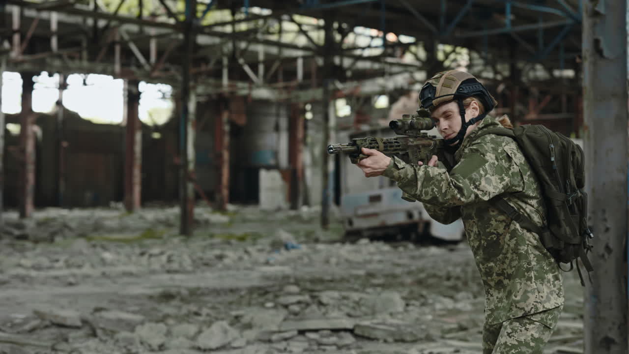 Woman Soldier in Camouflage Uniform with Rifle in a Ruined Building