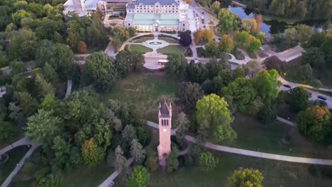 A drone shot of the iconic Iowa State Campanile, revealing the south side of campus bathed in warm sunset hues.