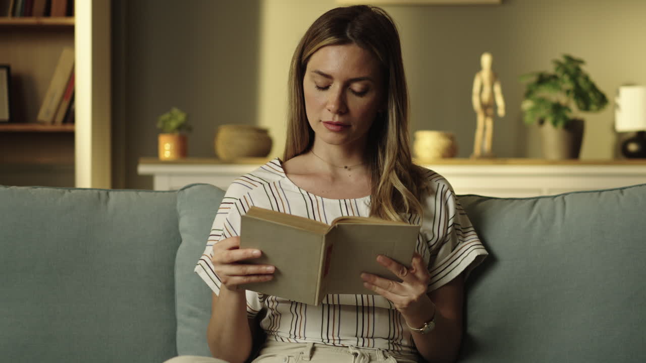 Donna che legge un libro sul divano