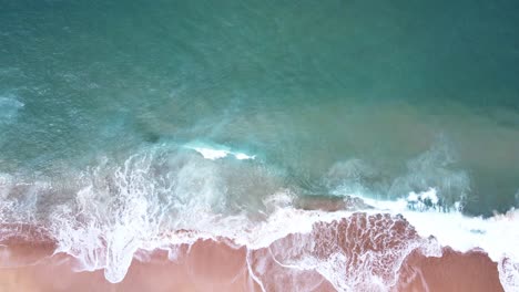 Aerial-Top-View-of-Ocean-Waves-Reaching-Beach-Shore